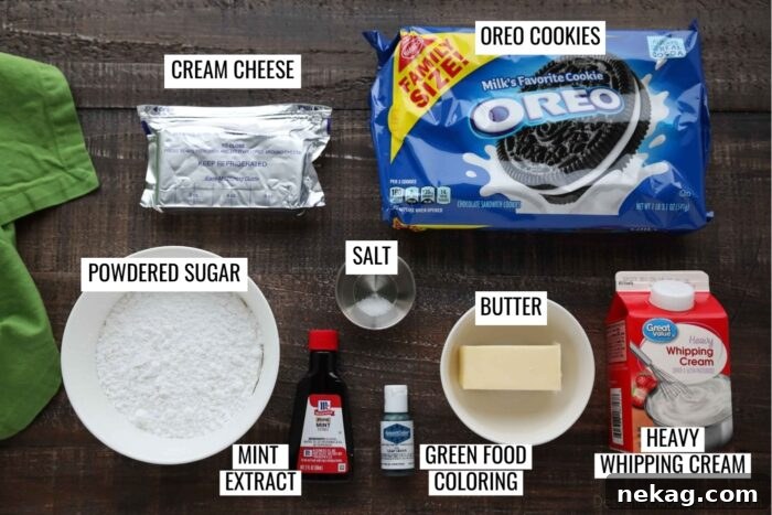 Various ingredients for Grasshopper Pie Recipe laid out: Oreo cookies, a stick of butter, cream cheese block, powdered sugar, salt, mint extract, green food coloring, and a carton of heavy whipping cream.