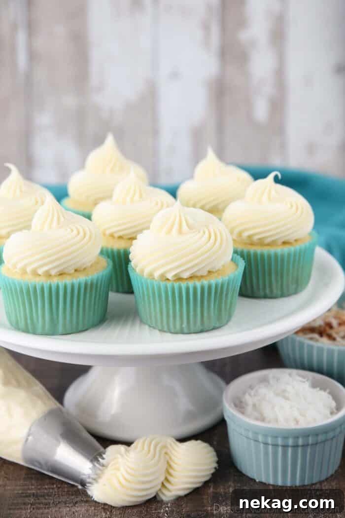 Cupcakes beautifully decorated with generous swirls of white coconut cream cheese frosting, ready to be enjoyed.