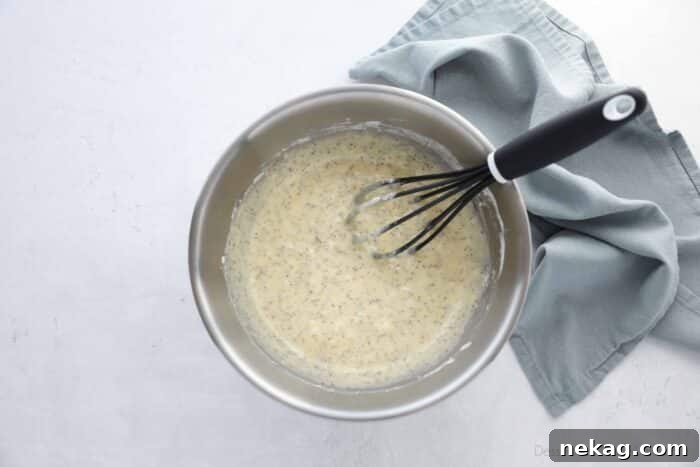 Golden Almond Poppy Seed Muffins 7 Close-up of almond poppy seed muffin batter in a mixing bowl.
