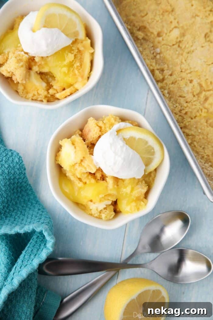 Effortless Lemon Sunshine Cake 2 A vibrant Lemon Dump Cake in a small serving bowl, garnished with a swirl of whipped topping and a fresh lemon slice, highlighting its delightful texture and appealing presentation.