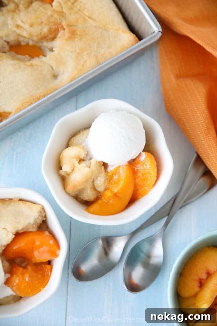 Effortless Peach Cobbler Perfection 2 Peach Cobbler with cake batter crust on top and a scoop of vanilla ice cream.