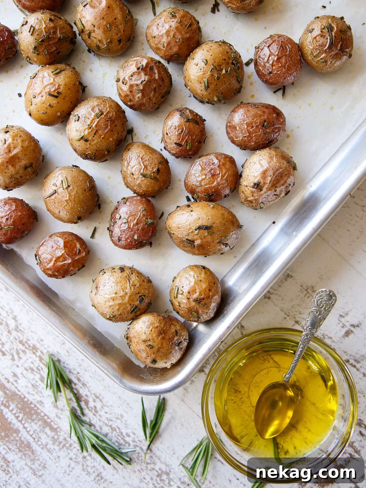 Rosemary Roasted Potatoes on baking sheet with rosemary sprigs