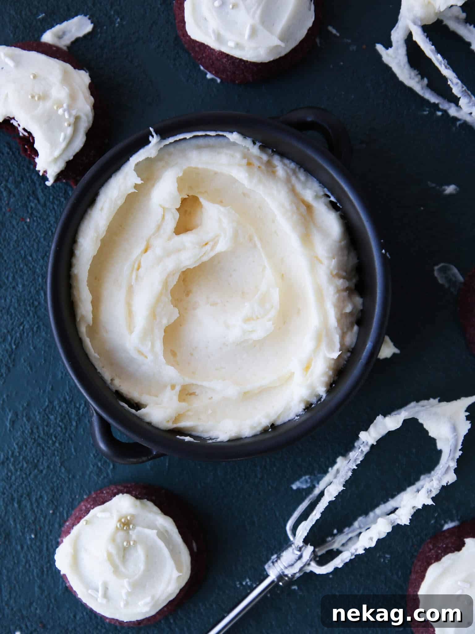 Cream Cheese Frosting being mixed with a paddle attachment in a stand mixer bowl.
