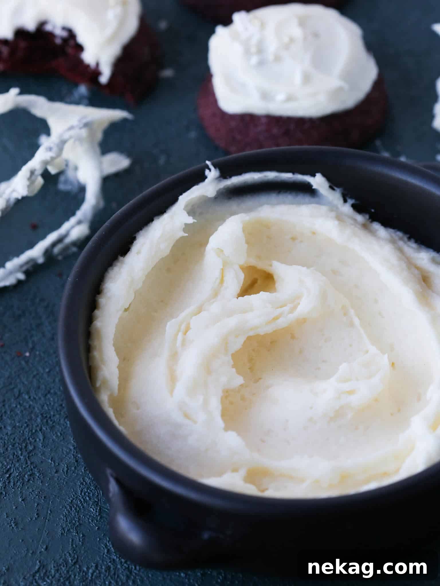Close-up texture of cream cheese frosting, showing its smoothness and slight peaks.