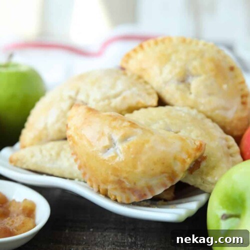 Single-serve apple pies with glaze.