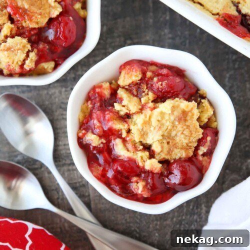 Bowl full of cherry dump cake made with cherry pie filling, cake mix, and butter.