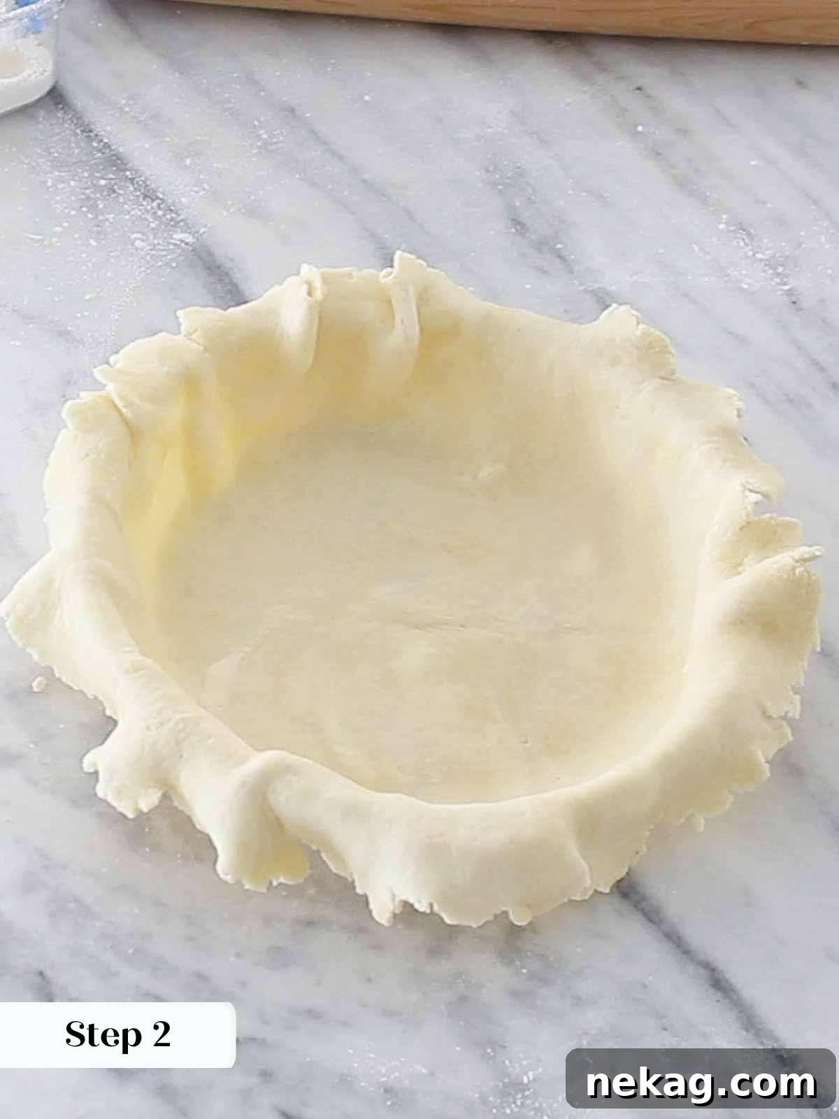 Pie dough carefully draped over a pie dish, with edges overhanging, preparing for trimming and fluting.