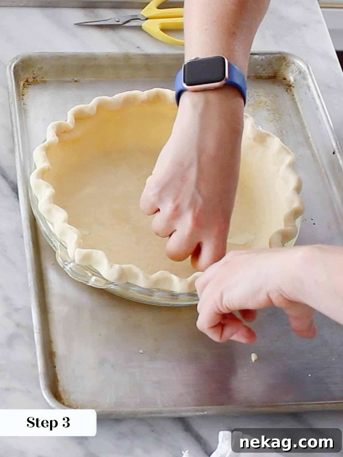 Hands demonstrating the art of fluting pie dough edges, creating a decorative and professional finish for the pie crust.