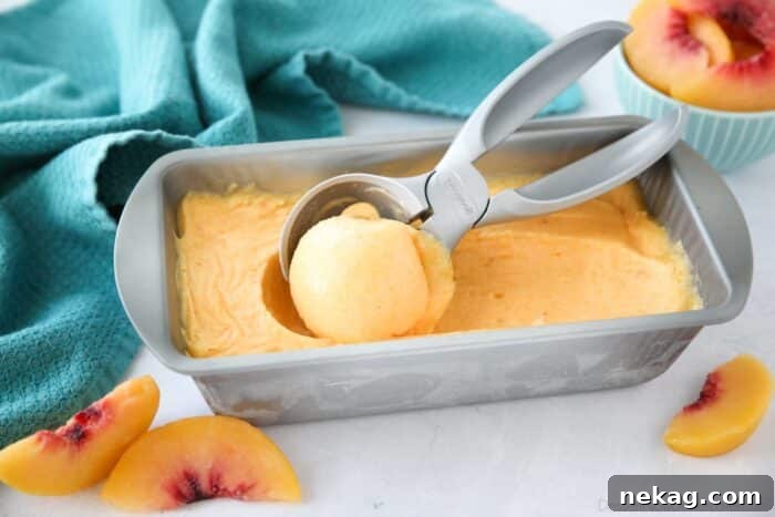 Smooth, homemade peach sorbet without an ice cream maker, perfectly frozen in a loaf pan, ready to be scooped.