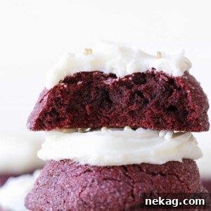The inside of a red velvet cookie stacked on top of another red velvet cookie, revealing its moist texture.