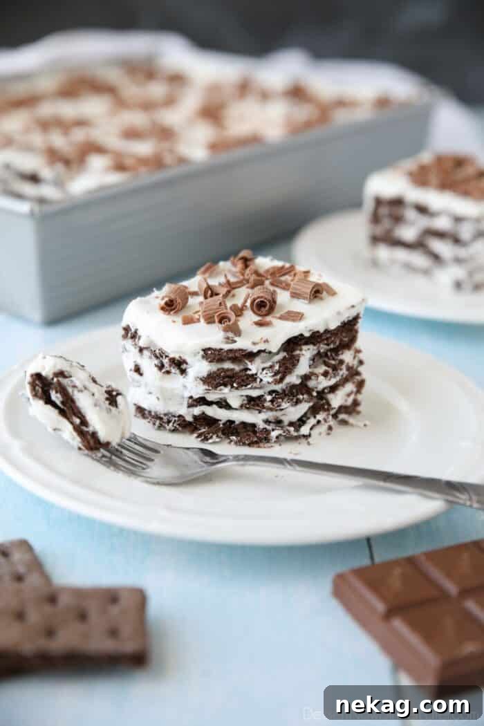 Icebox Cake with distinct layers of chocolate graham crackers and fluffy whipped cream, topped with elegant chocolate curls.