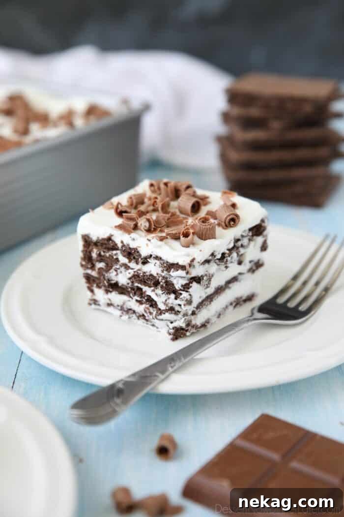 A delectable slice of chocolate icebox cake, featuring neat layers, placed on a white plate and garnished with chocolate shavings.