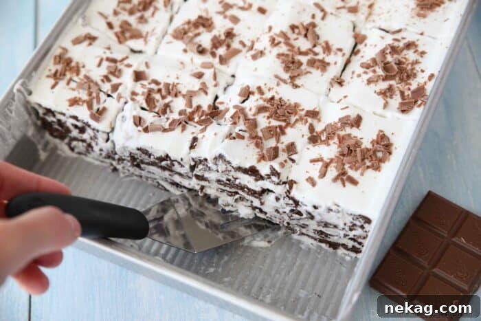 A pan of perfectly layered traditional icebox cake, made with chocolate graham crackers and sweet whipped cream, ready for chilling.