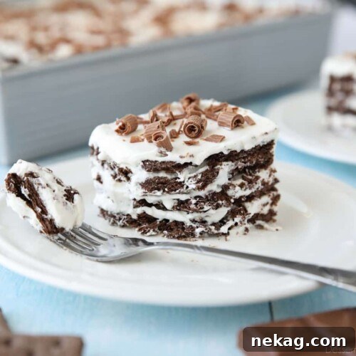 Icebox Cake with layers of chocolate graham crackers and whipped cream with chocolate curls on top.