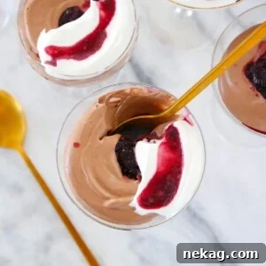 Rich Chocolate Mousse elegantly served in a glass with a golden spoon.