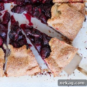 A baked Cherry Galette with Almond Buttermilk Crust, sliced on parchment paper.
