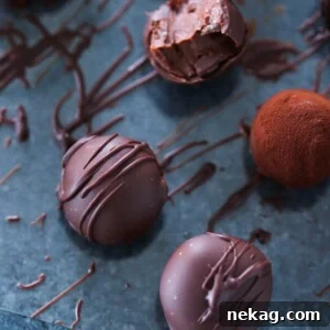 Elegant Bourbon Dark Chocolate Truffles arranged on a blue surface.