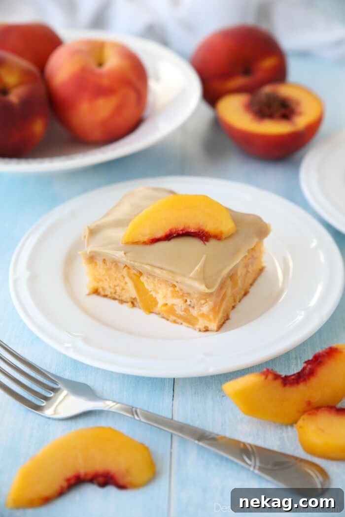A square piece of peach cake with brown sugar frosting on a plate.
