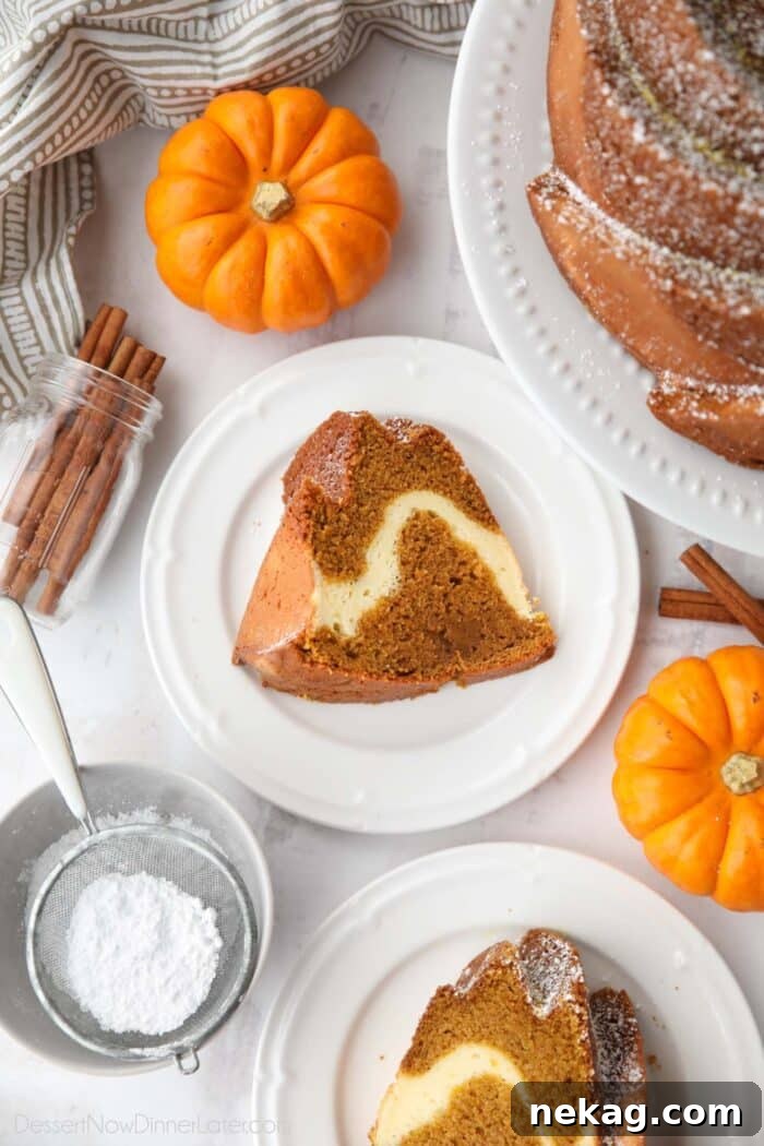 Spiced Pumpkin Bundt with Cream Cheese Swirl 4 A close-up of a slice of pumpkin bundt cake, showcasing the distinct swirl of creamy white cream cheese filling against the rich orange pumpkin cake.