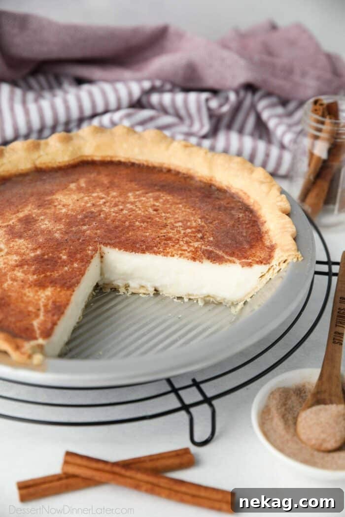 Homemade Sugar Cream Pie Recipe Video 3 A whole Sugar Cream Pie, with two slices already removed, showcasing its creamy interior and neatly crimped golden crust.