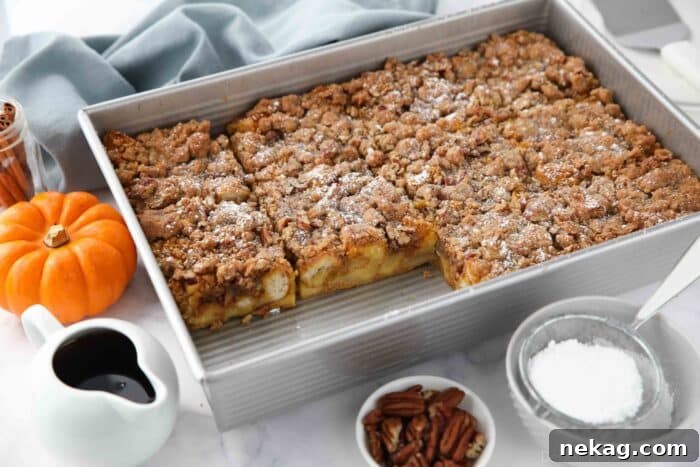 Fall Favorite Pumpkin French Toast Bake 12 A baking pan holds a partially served pumpkin French toast casserole, with two pieces already removed, revealing the rich, baked interior.