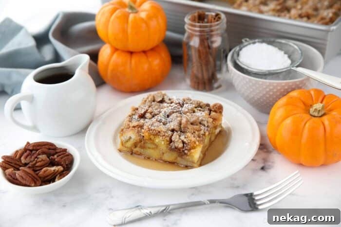 Fall Favorite Pumpkin French Toast Bake 5 A perfectly portioned square of pumpkin French toast casserole on a white plate, topped with a generous dusting of powdered sugar and a drizzle of syrup, showcasing its appealing texture and rich color.