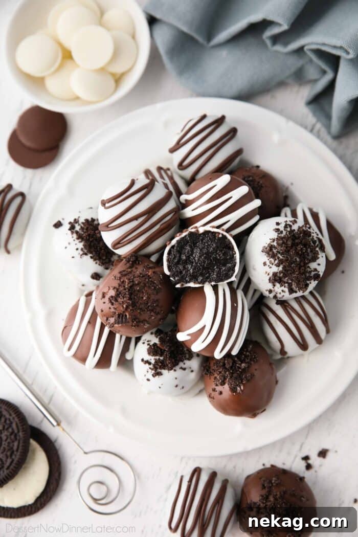 No Bake Oreo Truffles 2 Chocolate covered Oreo Balls on a plate with one cut open to see the inside.