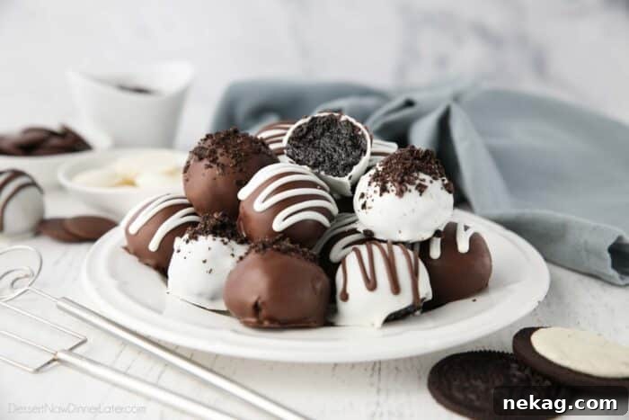 No Bake Oreo Truffles 12 A beautifully presented plate of Oreo Balls, with one cut open revealing the dark, creamy Oreo and cream cheese filling inside, coated in chocolate.