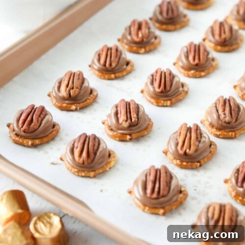 Rolo Pretzel Turtles on a baking sheet.