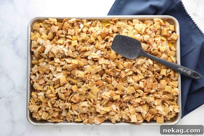 Coated cereal mixture spread out on a sheet pan, cooling and ready to be broken into individual pieces.