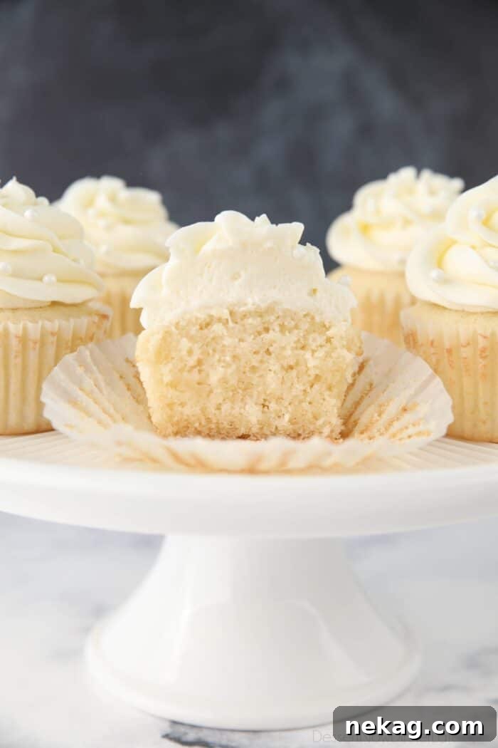 Perfectly Fluffy White Cupcakes 3 A white cupcake cut in half, revealing its light, fluffy, and tender texture, demonstrating a perfectly baked crumb.