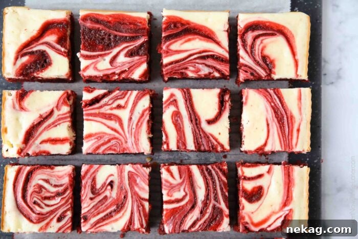 Perfectly cut squares of swirled red velvet cheesecake brownies, revealing their delicious layers.