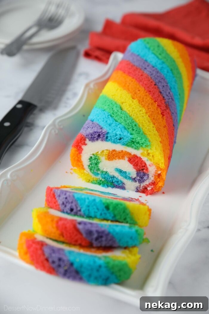 Rainbow Cake Roll with colored cake stripes and vanilla buttercream filling.