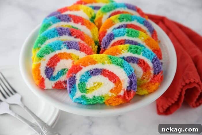 Slices of rainbow striped cake roll on a plate.