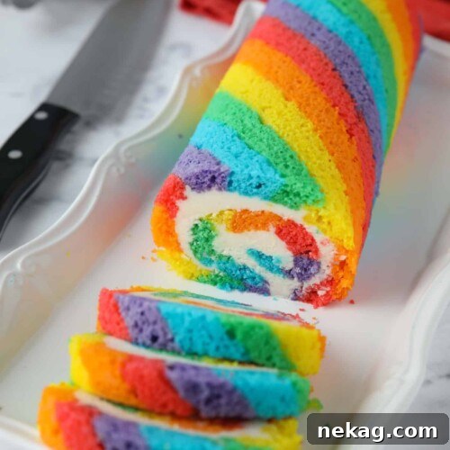 Rainbow Cake Roll with colored cake stripes and vanilla buttercream filling.