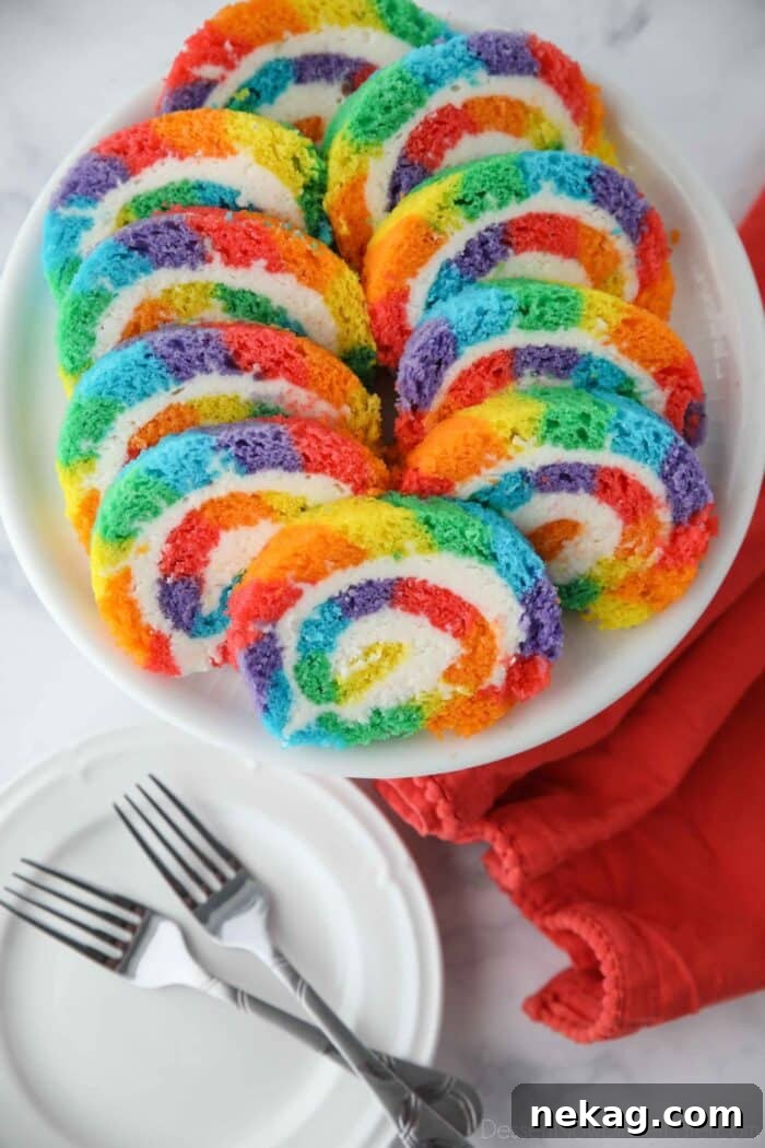 Slices of rainbow striped cake roll on a plate.