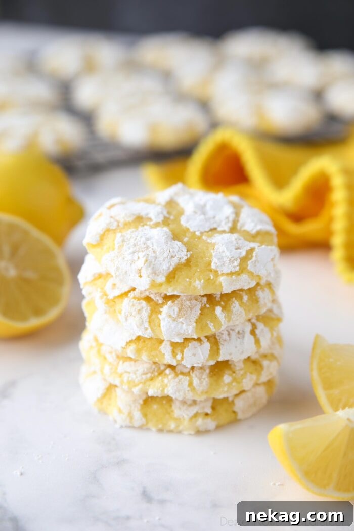 Stack of lemon crinkle cookies with powdered sugar on the outside.