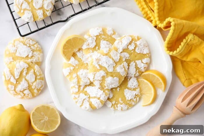 Plate of lemon crinkle cookies with lemon wedges.
