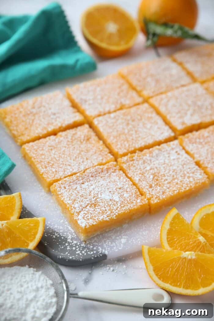 Golden Citrus Bars 3 Golden orange bar squares neatly arranged on a wooden cutting board, dusted with a light cloud of powdered sugar.