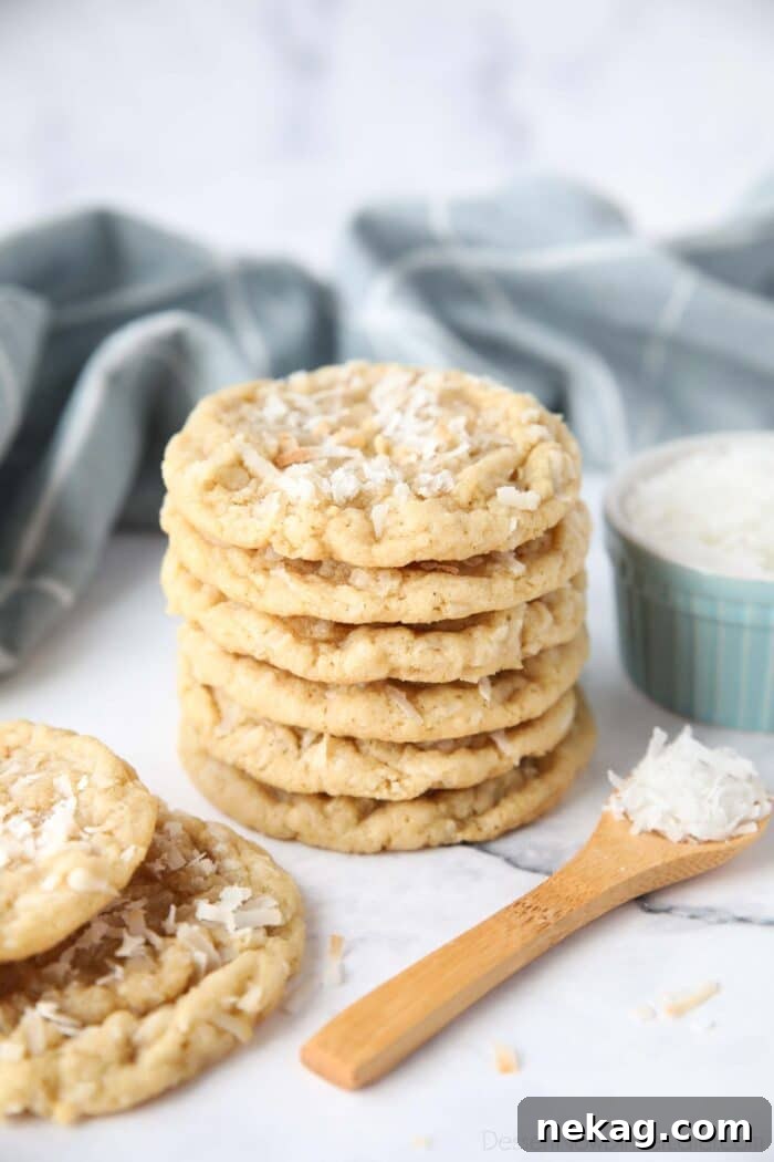 Irresistible Coconut Bites 2 A stack of soft and chewy coconut cookies with extra shredded coconut on top.