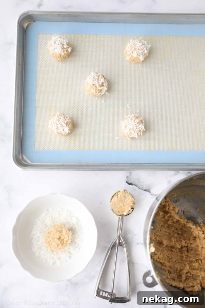 Irresistible Coconut Bites 6 Scooping cookie dough, topping it with coconut, and placing it on a baking tray.