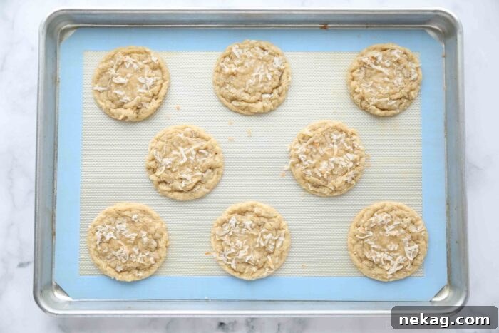 Irresistible Coconut Bites 7 Baked coconut cookies on a sheet tray, fresh from the oven.