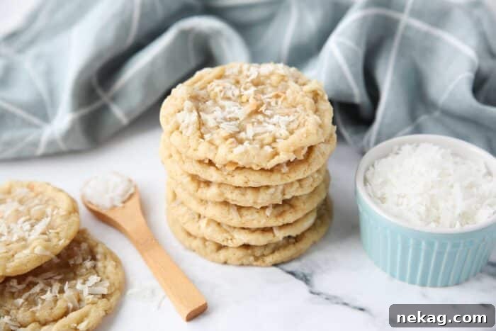 Irresistible Coconut Bites 8 A stack of soft and chewy coconut cookies with extra shredded coconut on top.