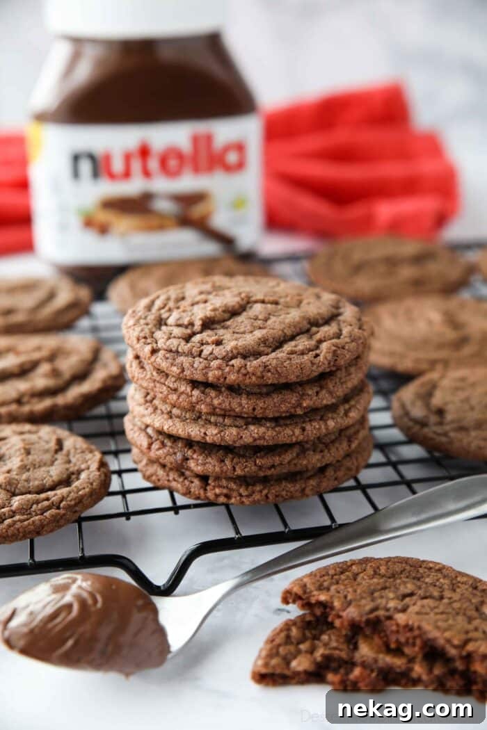 Stack of chocolate Nutella cookies on a wire cooling rack, showcasing their rich, fudgy texture and appealing cracks.