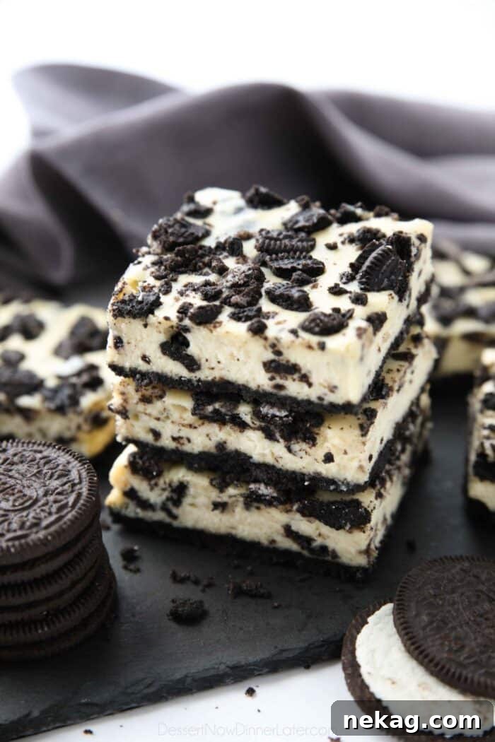 Oreo Crunch Cheesecake Bars 4 Three perfectly cut Oreo cheesecake bars stacked together, showcasing their distinct layers.