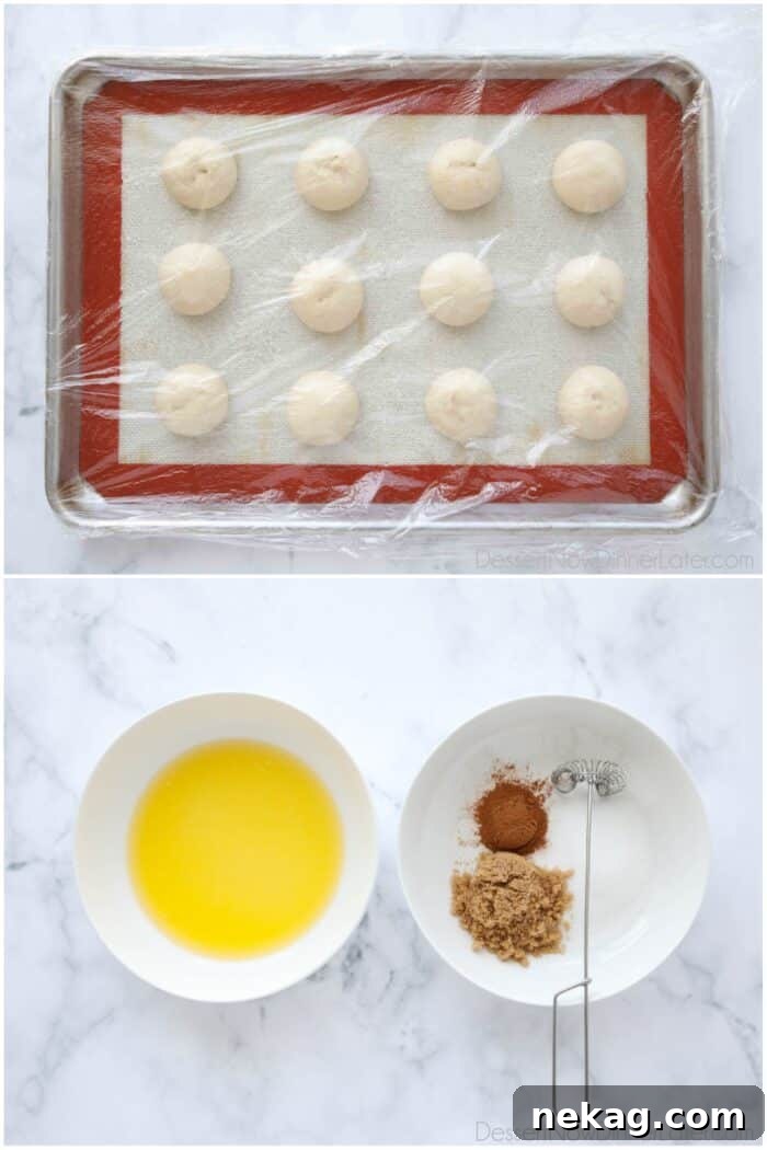 A selection of ingredients laid out on a marble surface: a bag of Rhodes rolls, sticks of butter, brown sugar, granulated sugar, and ground cinnamon.