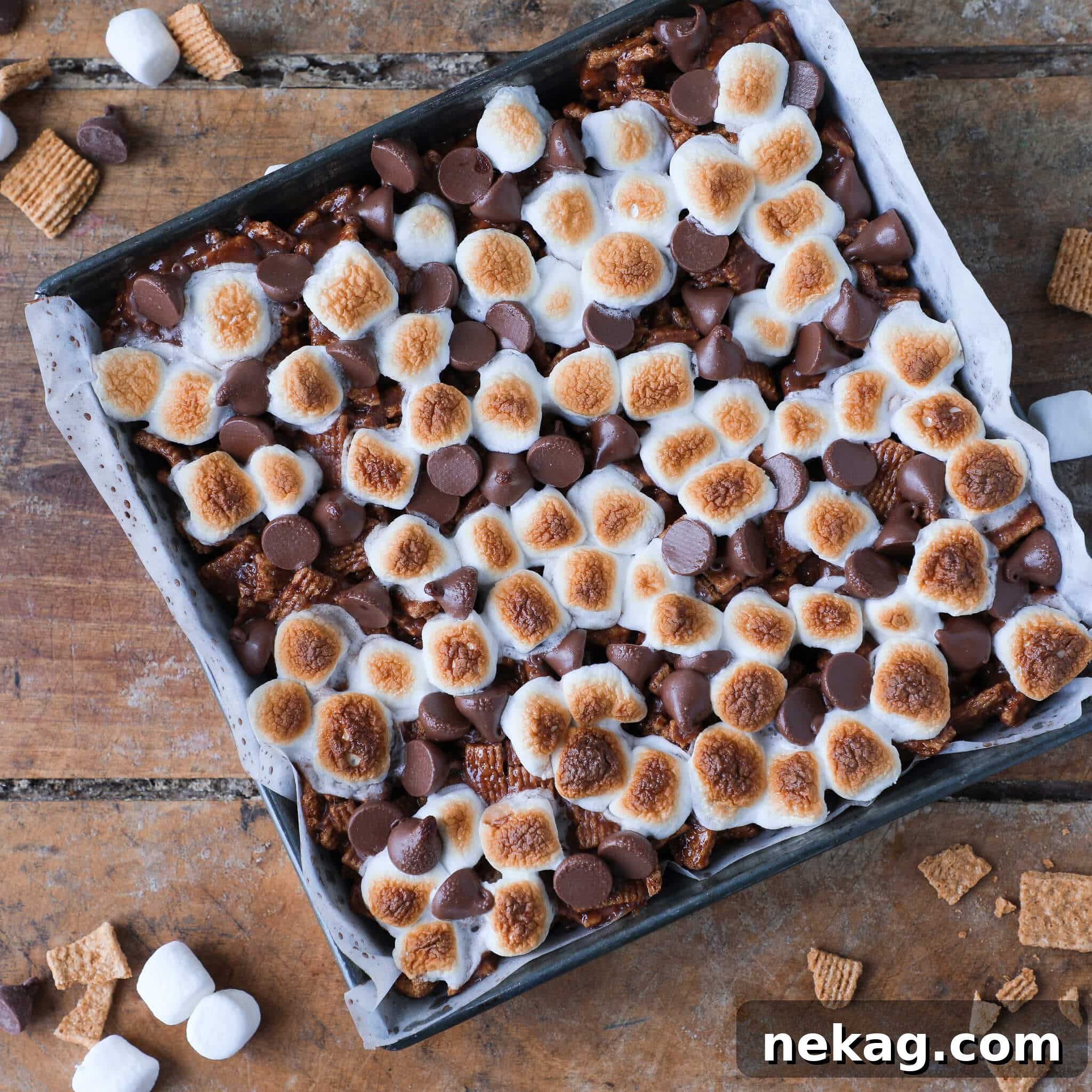 Uncut No Bake Golden Graham S'mores Bars in a vintage baking pan, showcasing their golden-brown toasted marshmallow topping.