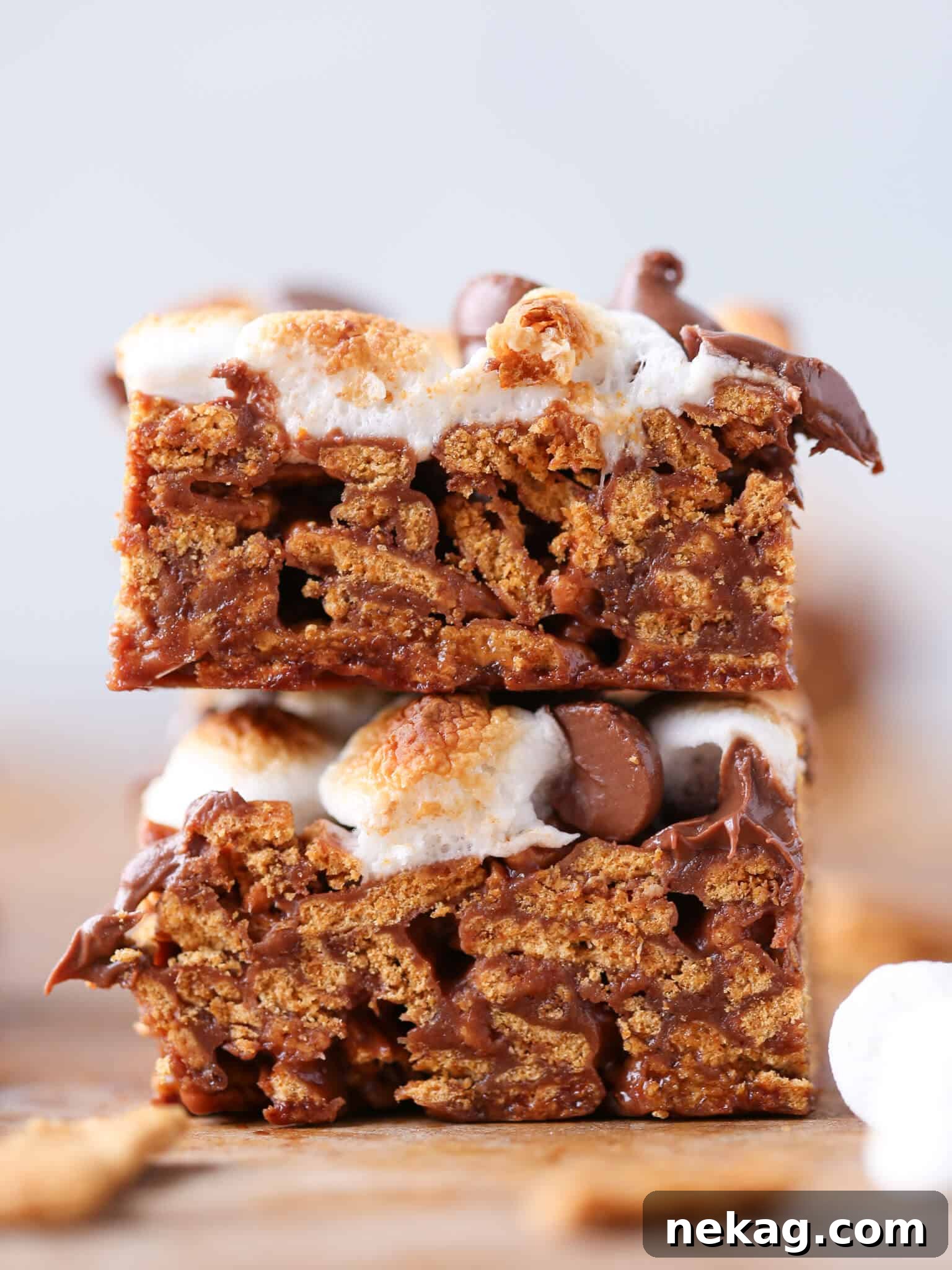 Close-up of a sliced No Bake Golden Graham S'mores Bar, showing the detailed layers of crispy cereal, melted chocolate, and soft marshmallow.