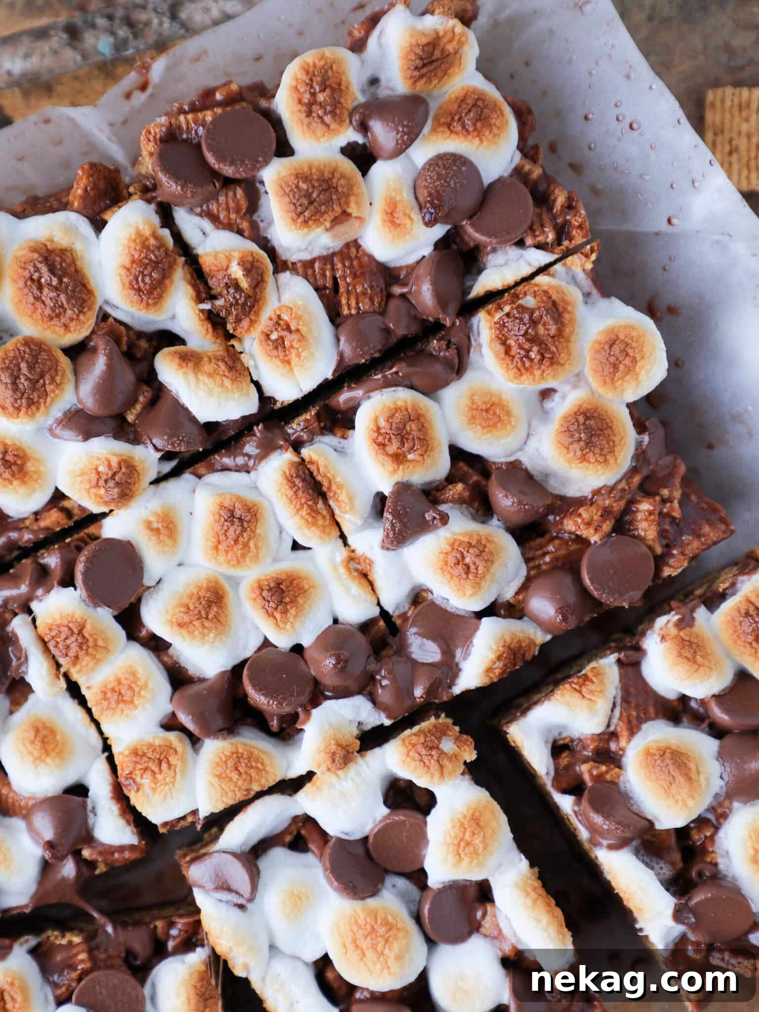 Several slices of No Bake Golden Graham S'mores Bars arranged neatly on parchment paper, highlighting their perfect shape and appealing textures.