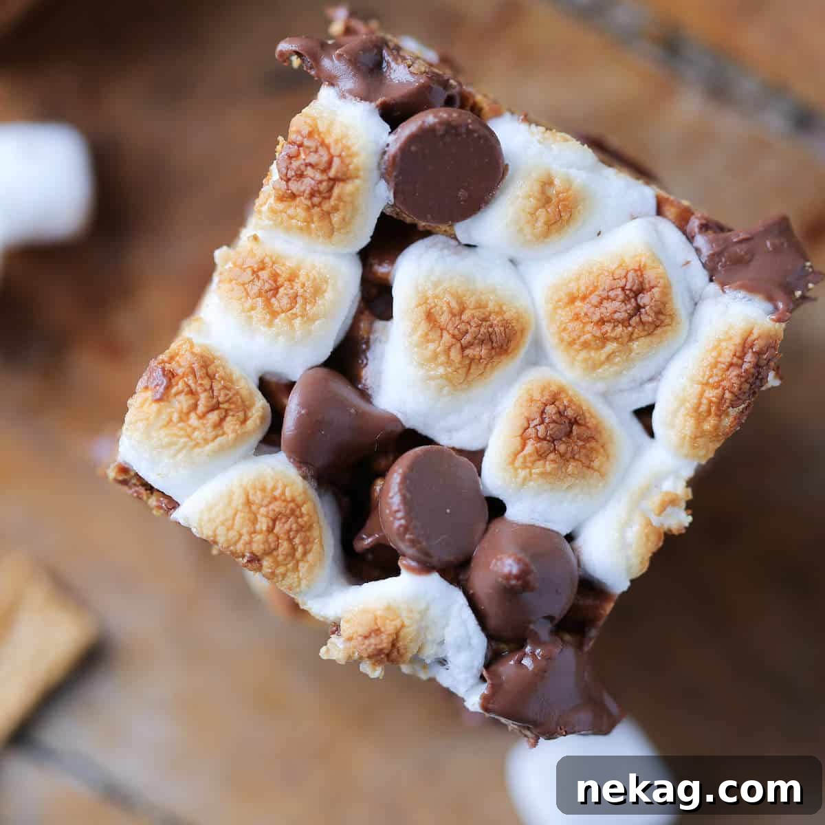 Close-up top-down view of the toasted marshmallow and chocolate topping on a No Bake Golden Graham S'mores Bar, showing intricate detail.